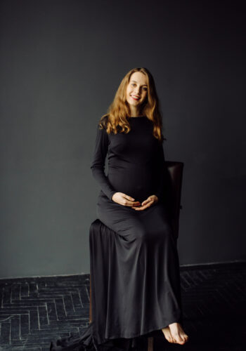 Young beautiful pregnant woman in black dress. Pregnancy fashion look concept